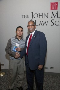 Javier Magana (left) is congratulated by John Marshall Law School Associate Dean Rory Smith (right) after Magana was presented a $5,000 tuition waiver for delivering the best closing argument at the 5th Annual High School Mock Trial Competition. Magana is a student at Chicago’s Hubbard High School.