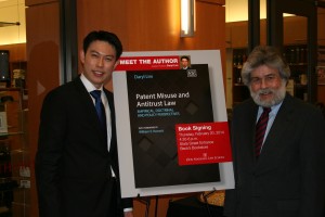 Professor Ralph Ruebner, associate dean for Academic Affairs, congratulates Professor Daryl Lim (left) at a reception celebrating the publication of Lim’s first book. Lim spent several years researching for the book on patent misuse.
